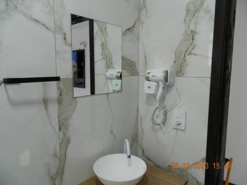 Estalagem Floradas da Serra في ساو جواكيم: حمام مع حوض ومرآة وهاتف