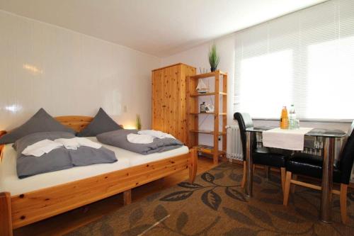 Schlafzimmer mit einem Bett, einem Tisch und einem Schreibtisch in der Unterkunft Ferienwohnung Düneneck 14 Gartenhaus in Sankt Peter-Ording