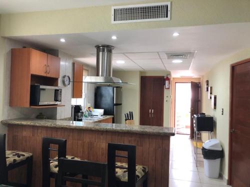 - une cuisine avec un comptoir avec des chaises et un comptoir dans l'établissement Amplio departamento en Marina, à Mazatlán