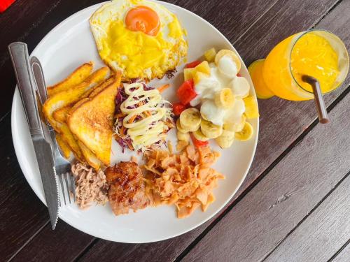 un plato de desayuno con tostadas de huevos y fruta en Koh Mook Sea View Bungalow en Ko Mook