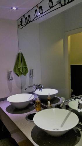 Un baño con dos lavabos y un espejo. en Superior Motel l, en Haifa