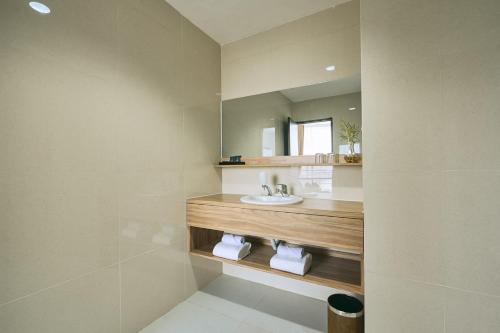 a bathroom with a sink and a mirror at Horison TC UPI Serang in Banjar
