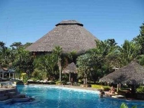 un resort con piscina e capanna di paglia di Casa Dpto en Rio selva Resort a Santa Cruz de la Sierra