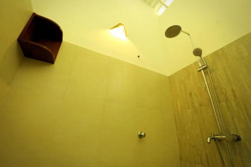 a bathroom with a shower with a shower head at Beach Grove Villas in Unawatuna