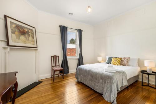 um quarto branco com uma cama e uma janela em Waterfront Bliss Family Retreat em Geelong