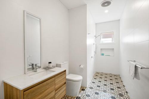 a white bathroom with a sink and a toilet at Waterfront Bliss Family Retreat in Geelong