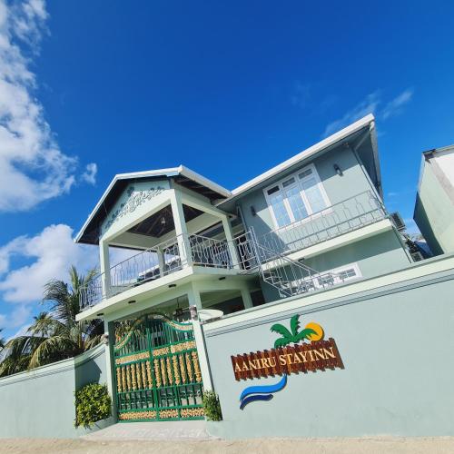 a large house with a sign in front of it at Aanirustayinn in Hoarafushi