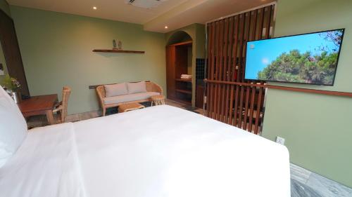 a bedroom with a bed and a flat screen tv at CHiEM HoiAn - The Beachside Boutique Hotel & Villa in Hoi An