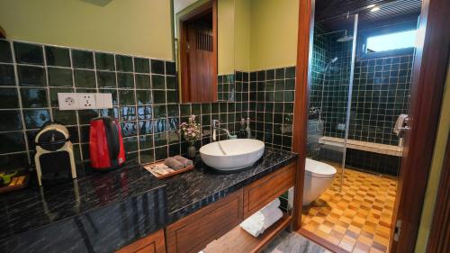 a bathroom with a sink and a toilet at CHiEM HoiAn - The Beachside Boutique Hotel & Villa in Hoi An