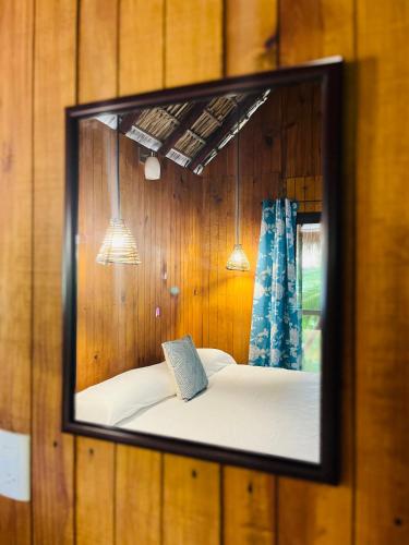 a mirror on a wall with a bed in a room at Blue House in Puerto Escondido