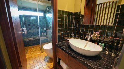 a bathroom with a sink and a toilet at CHiEM HoiAn - The Beachside Boutique Hotel & Villa in Hoi An
