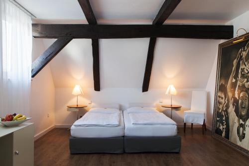 a bedroom with two beds and two tables at Hotel der Lennhof in Dortmund