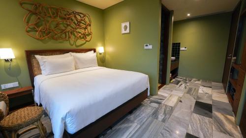 a bedroom with a large white bed and a chair at CHiEM HoiAn - The Beachside Boutique Hotel & Villa in Hoi An
