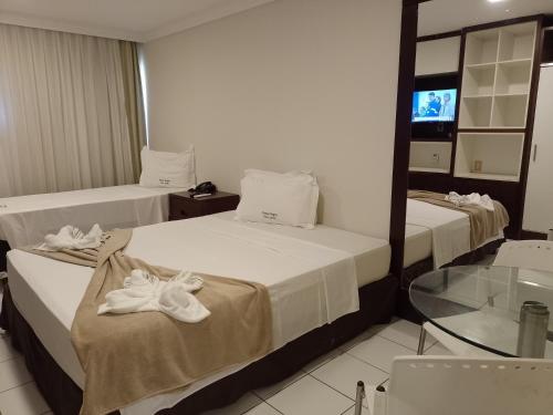 - 2 lits dans une chambre d'hôtel avec des serviettes dans l'établissement PONTA NEGRA FLAT APART, à Natal