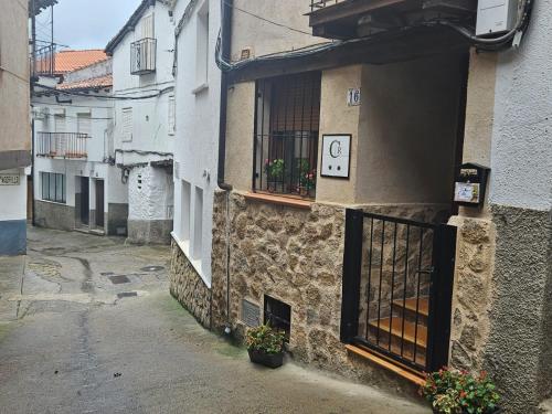 un callejón con un edificio con una ventana y plantas en El Nido, Casa Rural, en Casas del Castañar