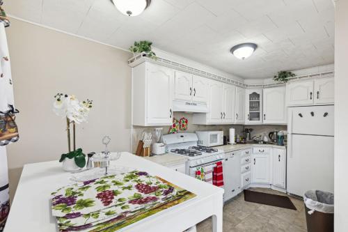 a kitchen with white cabinets and a white counter top at Charming Glenolden Townhouse in Glenolden