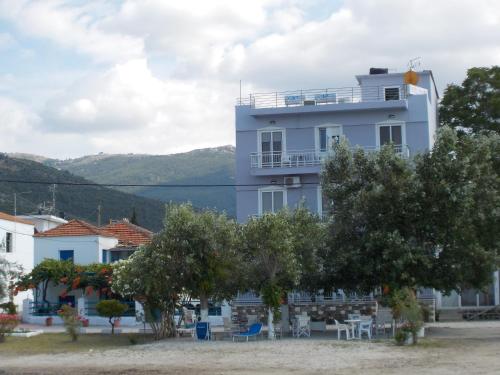 a white building with trees in front of it at Hotel Prinos in Prinos