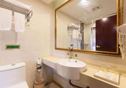 a white bathroom with a sink and a mirror at Vienna International Hotel - Shanghai Jiaotong University Humin Road in Shanghai