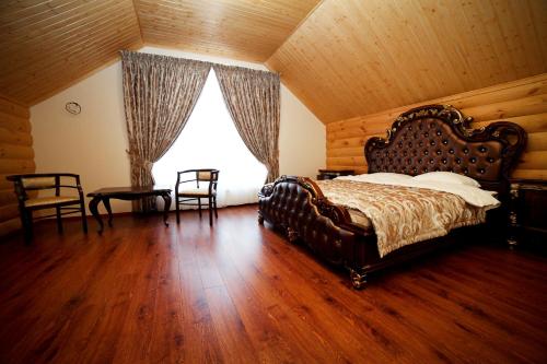 a bedroom with a large bed and a wooden ceiling at Alexandrovskaya Sloboda Hotel in Pervoye Maya