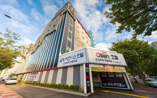 a tall building on a city street with at Olle Business Hotel in Gwangju
