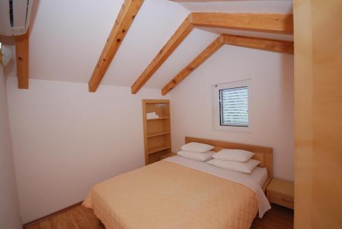 a bedroom with a bed with white sheets and pillows at Springs Apartments & Rooms in Sveti Stefan