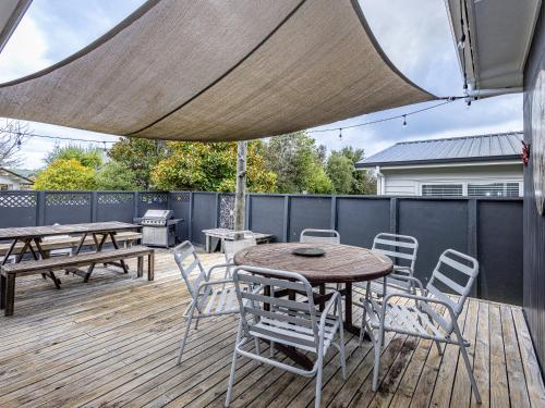 a patio with a table and chairs on a deck at Our Happy Place - Kinloch Holiday Home in Kinloch