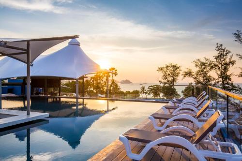a group of chairs sitting next to a swimming pool at Beyond Patong in Patong Beach