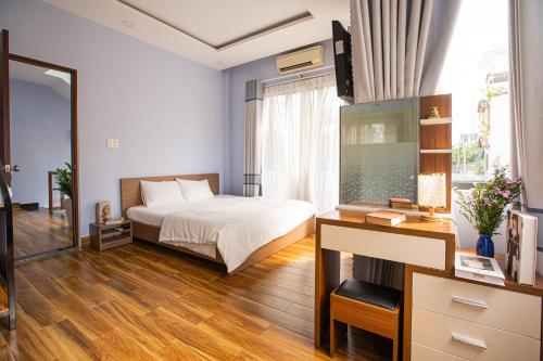 a bedroom with a bed and a desk and a mirror at Leila House - 3BRs - Central Danang in Da Nang