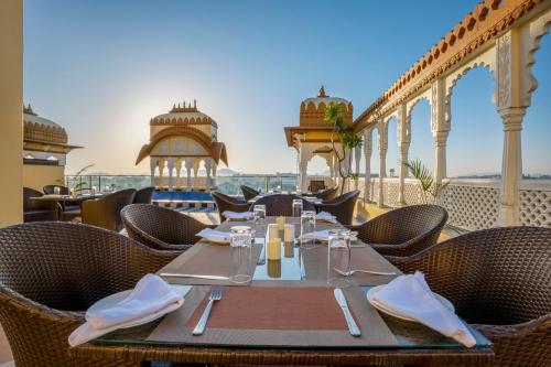un restaurante con mesa y sillas en el balcón en Sterling Balicha Udaipur, en Udaipur