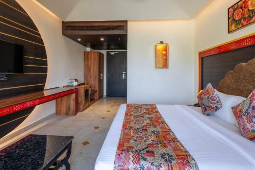 a hotel room with a bed and a tv at Sterling Balicha Udaipur in Udaipur