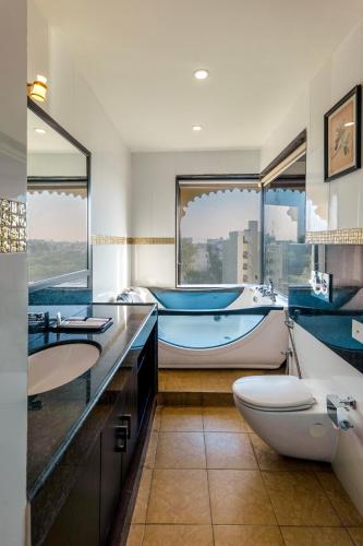 a bathroom with two sinks and a tub and a boat at Sterling Balicha Udaipur in Udaipur
