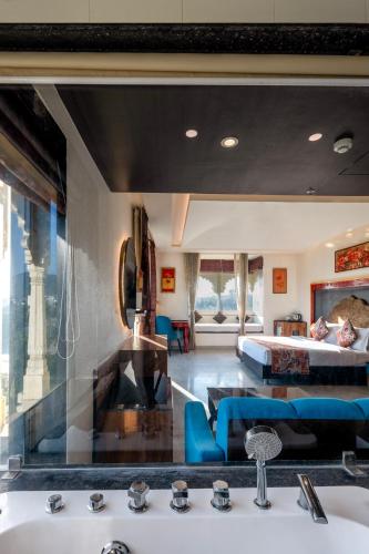 a bathroom with a sink and a bedroom with a bed at Sterling Balicha Udaipur in Udaipur