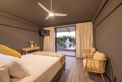 a bedroom with a bed and a window with a fountain at Townsville Eco Resort 