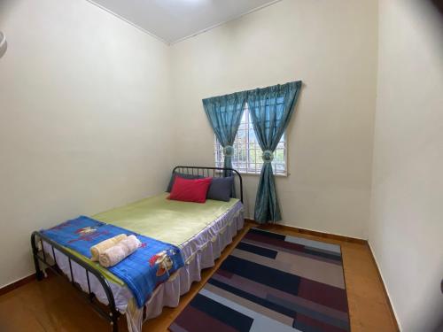 a small bedroom with a bed and a window at Homestay D'Bukit in Jeli