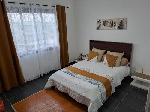 Un dormitorio con una cama y una ventana grande. en La Villa Manaïck, en Saint-André