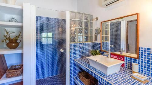 Baño de azulejos azules con lavabo y espejo en Casa Rural Aguasal El Bosque by Ruralidays, en El Bosque