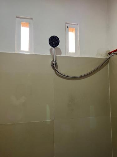 um chuveiro na casa de banho com 2 janelas em Ulina Homestay VIP Berastagi em Berastagi