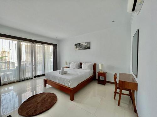 1 dormitorio con cama, mesa y escritorio en CG Guesthouse Canggu en Canggu