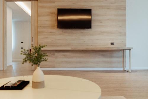 a living room with a table and a tv on a wall at RUS Hotel&Convention Ayutthaya in Phra Nakhon Si Ayutthaya