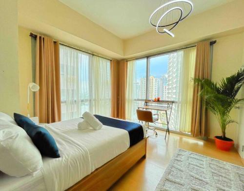 een slaapkamer met een bed en een groot raam bij Avant at the Fort BGC Corner Unit with Scenic View in Manilla