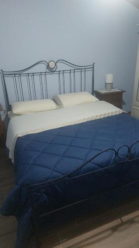 Una cama con una manta azul encima. en Agriturismo Dolci Ricordi, en Corleto Monforte