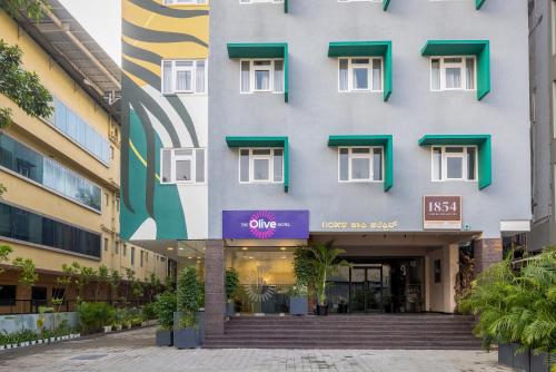 un edificio con un letrero púrpura en el costado. en Olive JP Nagar - by Embassy Group en Bangalore
