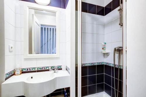 une salle de bain avec un lavabo et un miroir dans l'établissement Port du Crouesty Cap'Océan - maeva Home - Appartement 2 pièces 4 personnes - Sélection MAE-1318, à Arzon