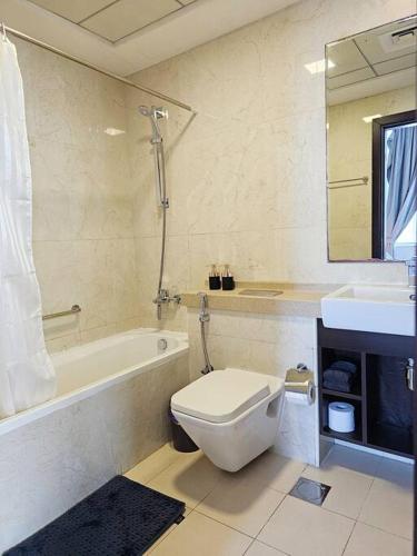 uma casa de banho com um WC, uma banheira e um lavatório. em Luxury Botanica Apartment 121 em Dubai