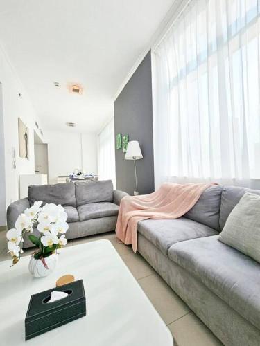 uma sala de estar com um sofá e uma mesa em Luxury Botanica Apartment 121 em Dubai