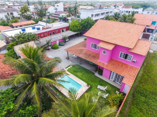 uma vista aérea de uma casa com piscina em Suítes casa rosada em Cabo Frio