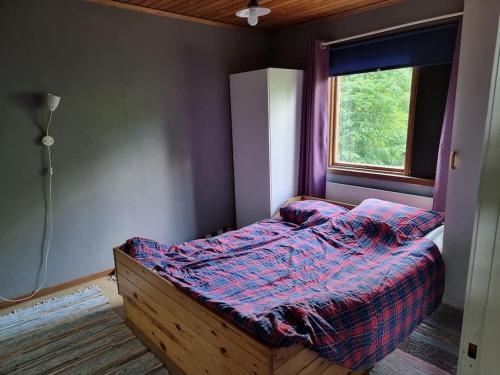 a small bed in a room with a window at Rustikales Hexenhäuschen in Stöde