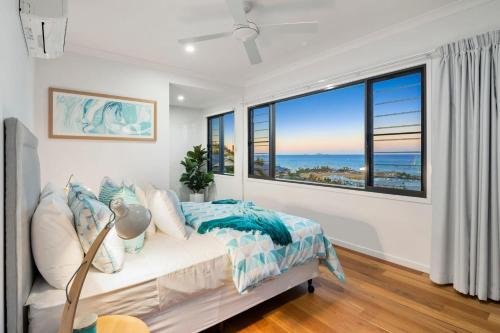 a bedroom with a bed and a large window at Relax & Daydream at 2 Elementa in Airlie Beach