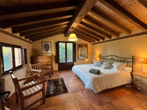 ein Schlafzimmer mit einem großen Bett und einer Holzdecke in der Unterkunft Villa El Molino Blanco in Molinos de Razón