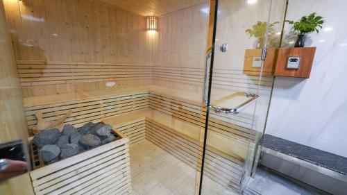 a sauna with a shower and some rocks in it at CHiEM HoiAn - The Beachside Boutique Hotel & Villa in Hoi An